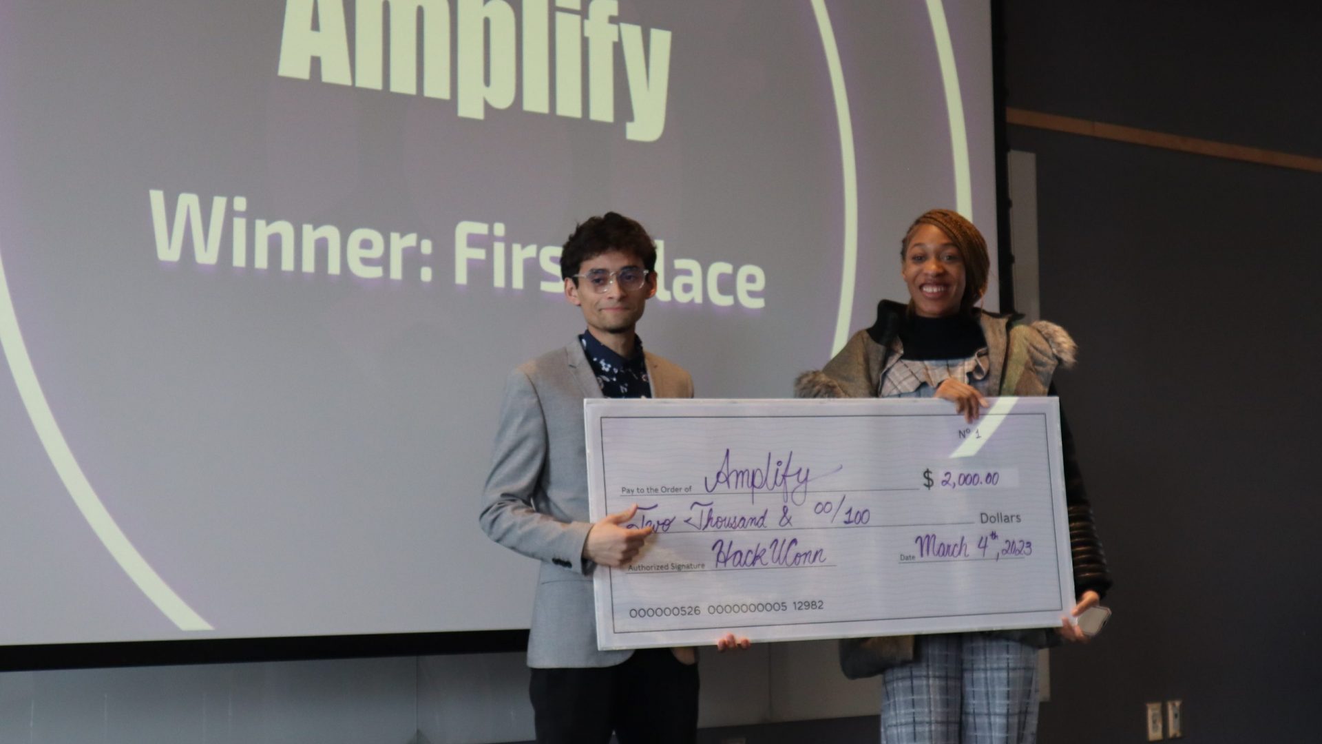 Adama Modi and Kenny Pineda, members of team "Werth Innovators" stand with the grand prize check in their hands.